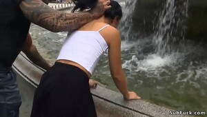 Slender brunette wet at public fountain